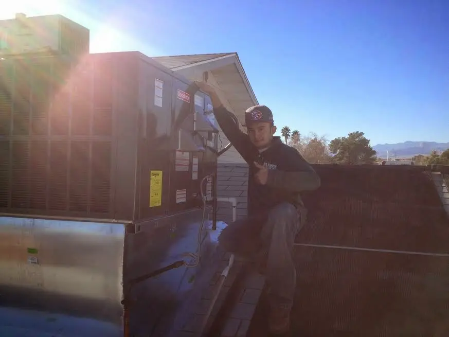 HVAC technician performing Air Duct Repair on a rooftop unit in Hot Springs Village